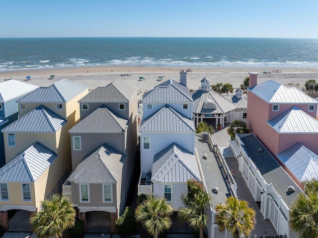 aerial view with a view of the beach, a water view, and a residential view