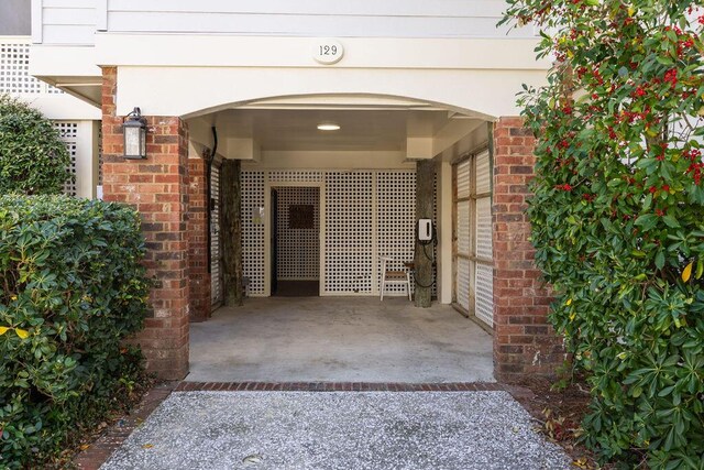 entrance to property featuring brick siding and driveway