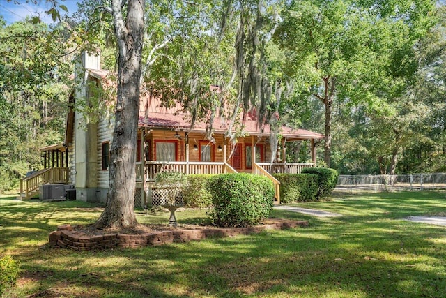 view of front of house with a front yard, a porch, and central AC