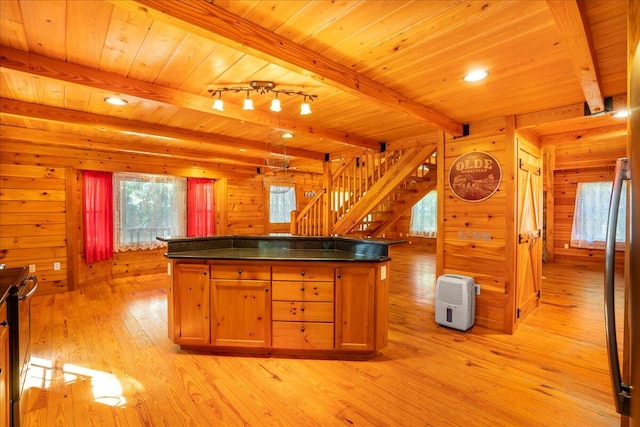 kitchen with beamed ceiling, wooden walls, light hardwood / wood-style floors, and wooden ceiling