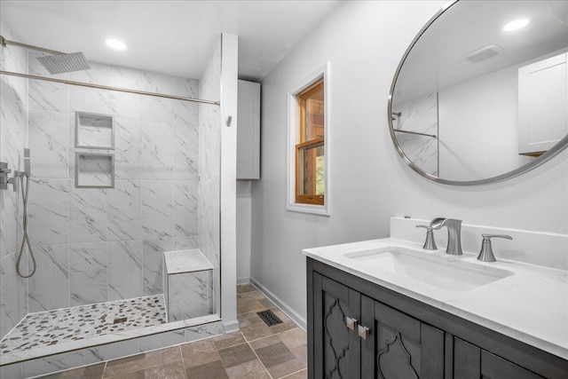 bathroom with vanity and tiled shower