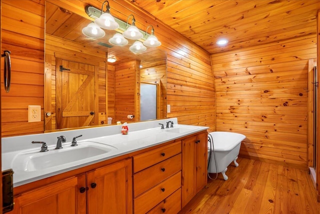 bathroom with vanity, hardwood / wood-style flooring, wood walls, and plus walk in shower