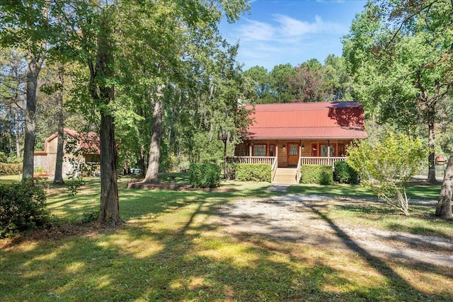 single story home featuring covered porch and a front yard