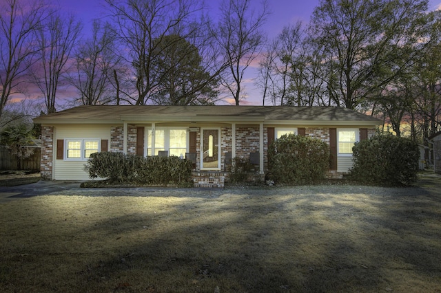 ranch-style home featuring a lawn