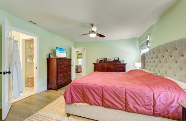 bedroom featuring ceiling fan, light hardwood / wood-style flooring, and ensuite bathroom