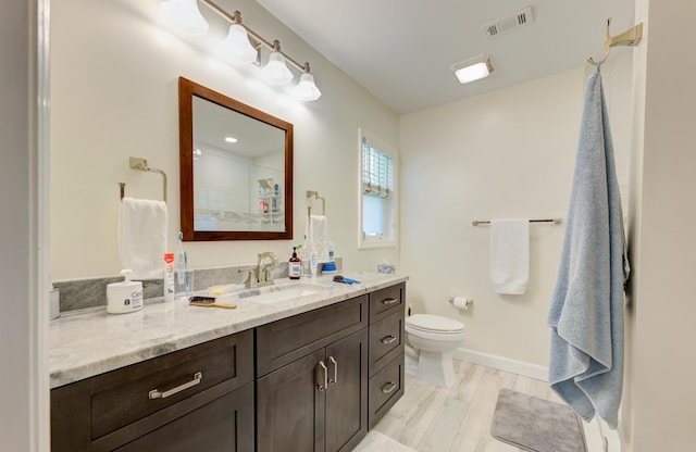 bathroom with hardwood / wood-style floors, vanity, toilet, and walk in shower