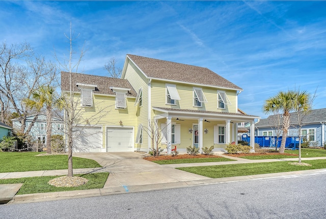 view of front of house with a porch, a garage, and a front lawn