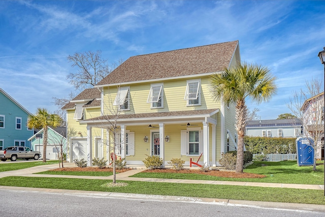 view of front of home featuring a front yard, ceiling fan, and a porch