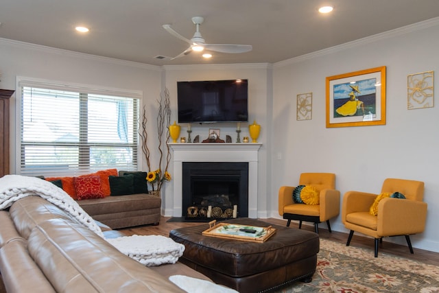 living room featuring hardwood / wood-style floors, ceiling fan, and crown molding