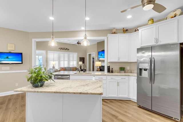 kitchen with decorative light fixtures, sink, white cabinetry, and stainless steel appliances