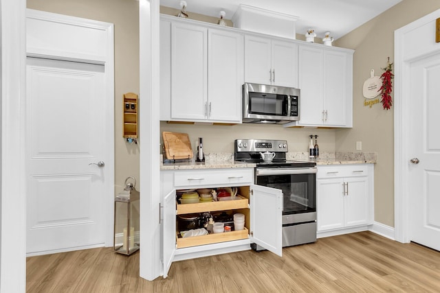 kitchen featuring white cabinets, stainless steel appliances, light stone countertops, and light hardwood / wood-style floors