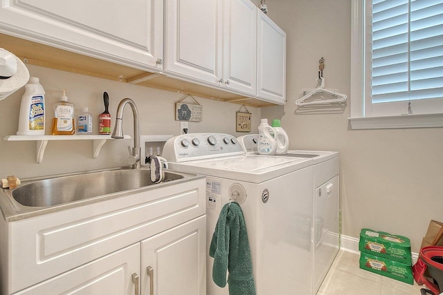 laundry area featuring sink, light tile patterned floors, cabinets, and independent washer and dryer