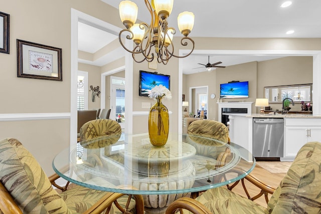 dining space featuring sink, a healthy amount of sunlight, and ceiling fan with notable chandelier