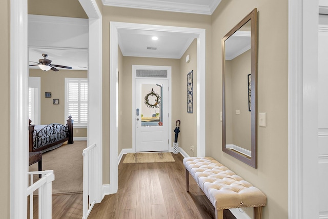 foyer with hardwood / wood-style flooring, ceiling fan, and ornamental molding