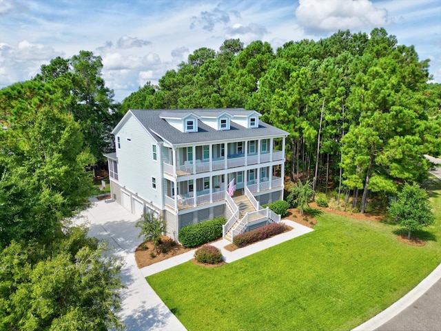 back of property featuring covered porch, a lawn, and a garage