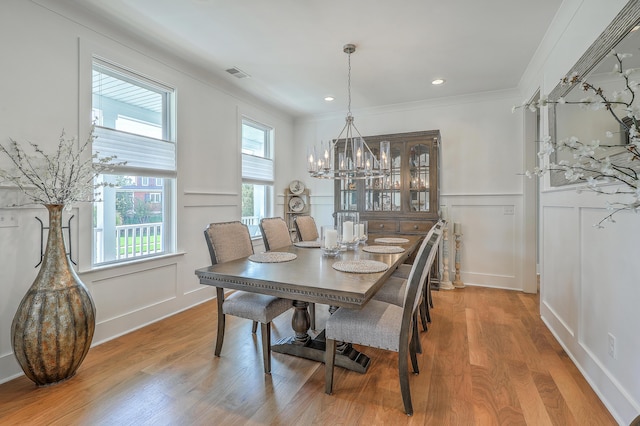 dining space with ornamental molding and hardwood / wood-style floors