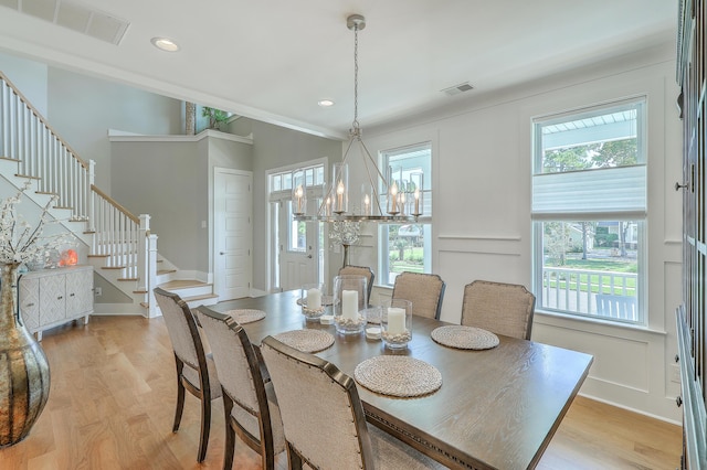 dining space featuring light wood-type flooring and an inviting chandelier