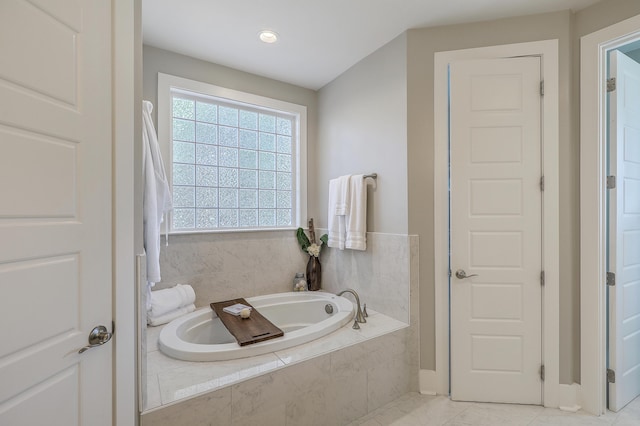 bathroom featuring a relaxing tiled tub and tile patterned floors