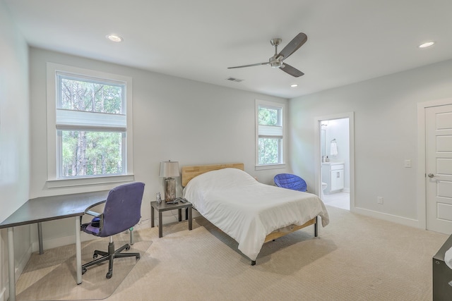 carpeted bedroom with ceiling fan, multiple windows, and ensuite bath