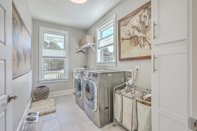 laundry area with light tile patterned floors, separate washer and dryer, and plenty of natural light