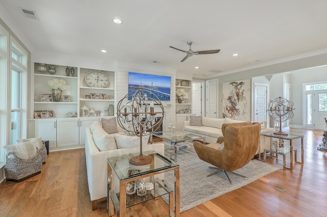 living room featuring ceiling fan, light hardwood / wood-style floors, and crown molding