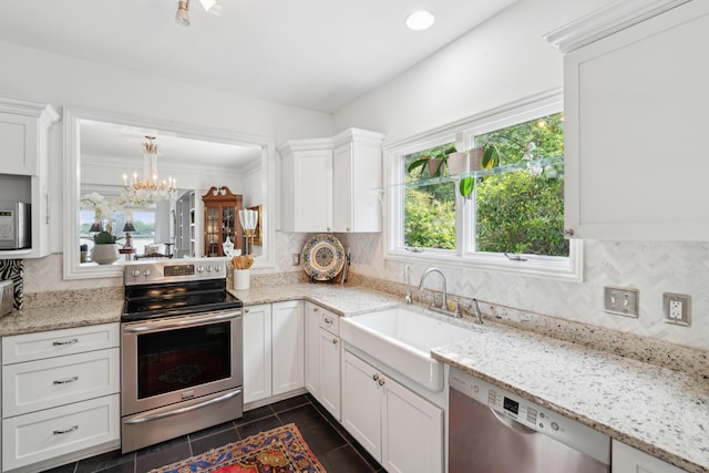 kitchen with a sink, tasteful backsplash, stainless steel appliances, and a notable chandelier