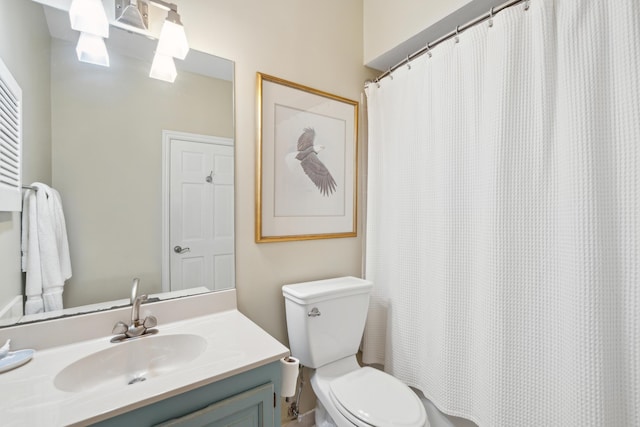 bathroom featuring toilet, a shower with shower curtain, and vanity