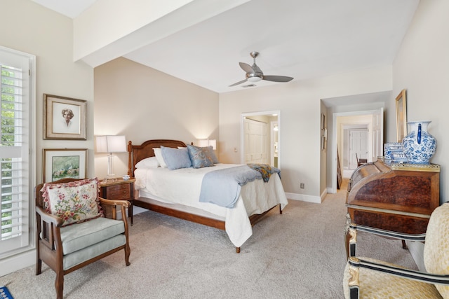 bedroom with ceiling fan, light carpet, baseboards, and ensuite bathroom