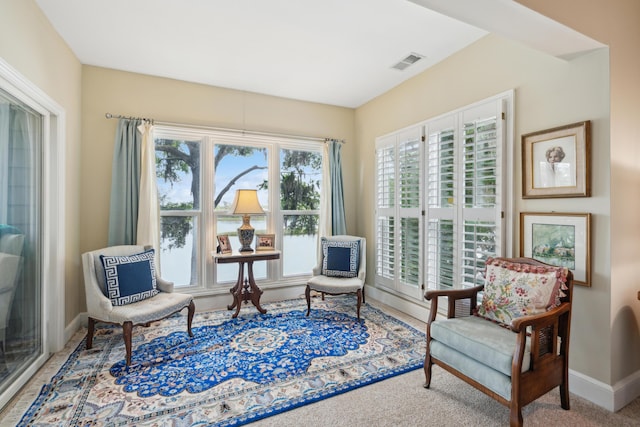 living area with baseboards and visible vents