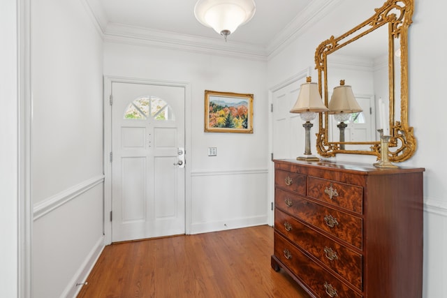 foyer with baseboards, crown molding, and wood finished floors