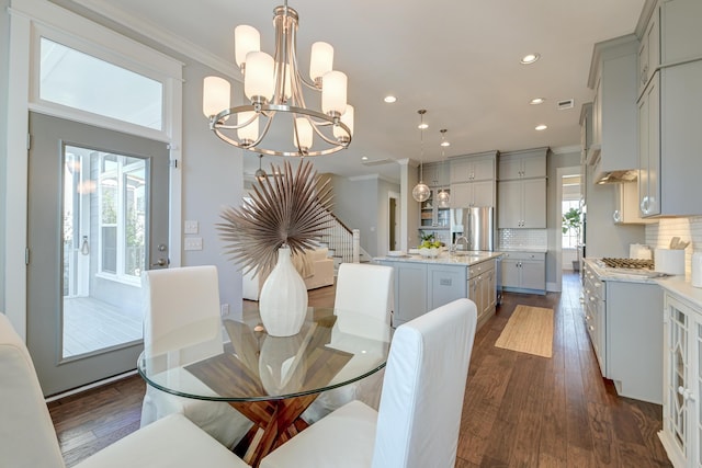 dining space with dark wood-type flooring, a chandelier, stairway, ornamental molding, and recessed lighting