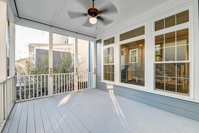 unfurnished sunroom with a ceiling fan