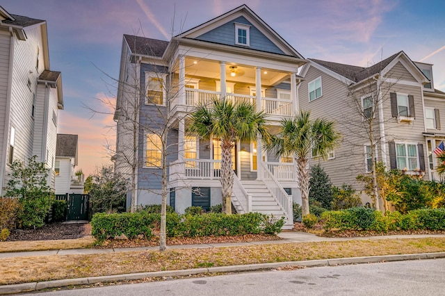 view of front of property featuring stairway, a balcony, and covered porch