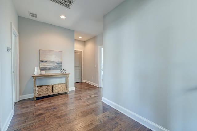 corridor featuring recessed lighting, visible vents, baseboards, and wood finished floors