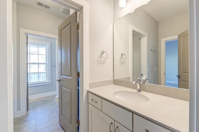 bathroom with vanity, baseboards, visible vents, tile patterned floors, and toilet