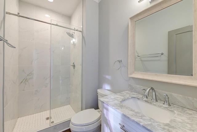 bathroom featuring vanity, a shower stall, and toilet