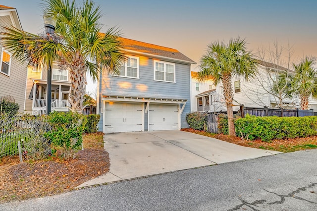 view of front of property with an attached garage, fence, and driveway