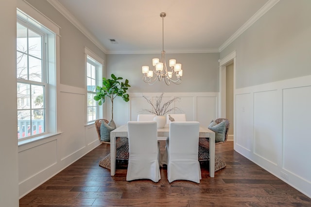 dining space featuring visible vents, dark wood-type flooring, a notable chandelier, and a decorative wall