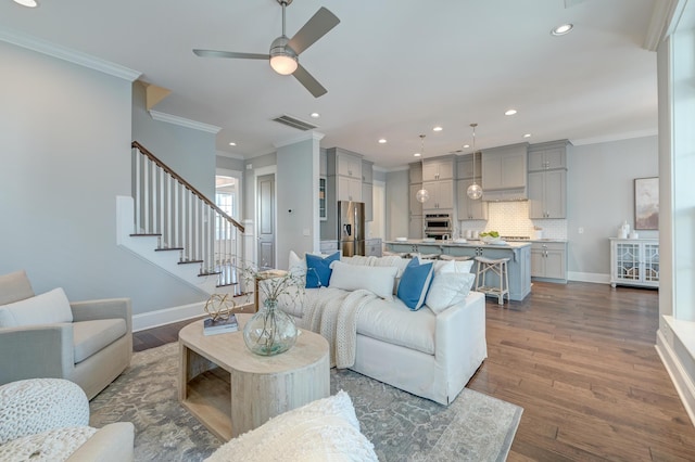 living area with dark wood-style floors, baseboards, and ornamental molding