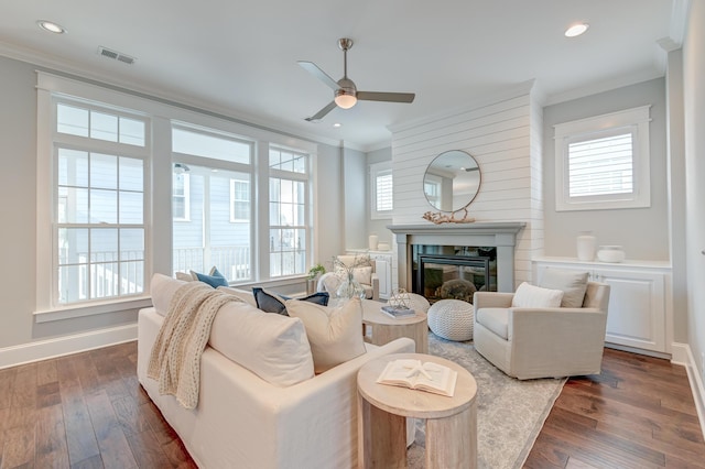 living room featuring visible vents, plenty of natural light, dark wood-type flooring, and crown molding