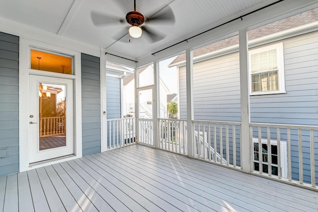 unfurnished sunroom featuring a ceiling fan