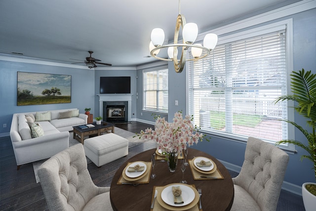 living room with ceiling fan with notable chandelier, dark hardwood / wood-style flooring, plenty of natural light, and crown molding