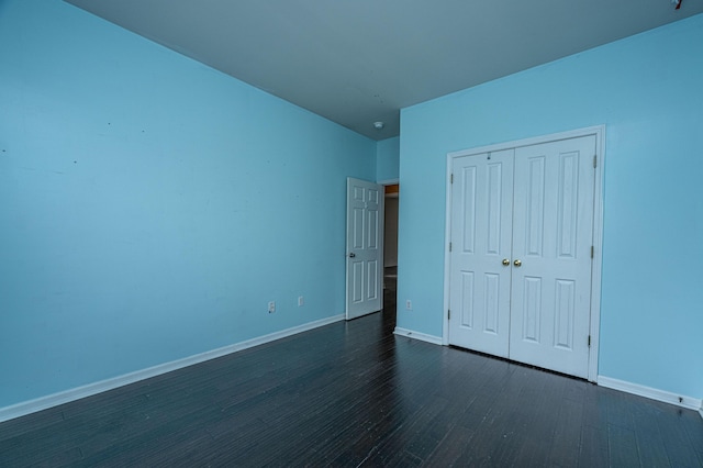 unfurnished bedroom with a closet and dark hardwood / wood-style floors