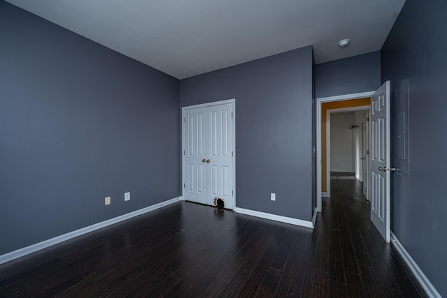 unfurnished bedroom featuring dark hardwood / wood-style flooring and a closet