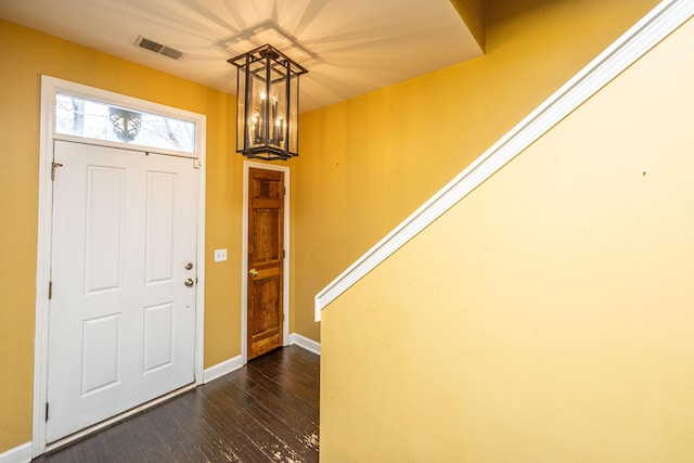 foyer featuring dark hardwood / wood-style flooring and an inviting chandelier