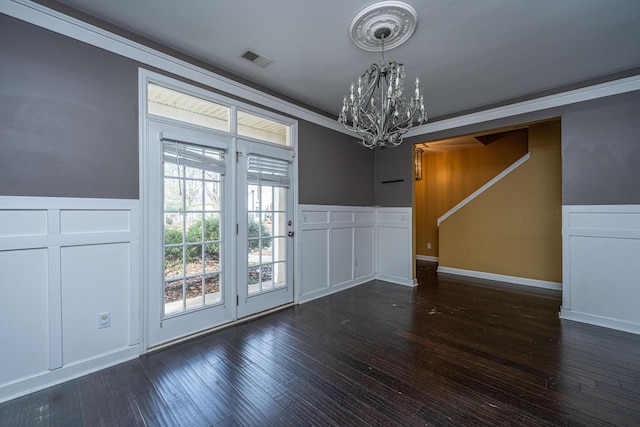 interior space with a notable chandelier, crown molding, and dark wood-type flooring