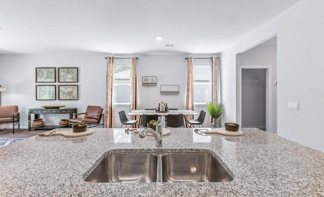 kitchen featuring light stone counters, sink, and a wealth of natural light