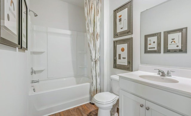 full bathroom with hardwood / wood-style flooring, vanity, shower / bath combination with curtain, and toilet