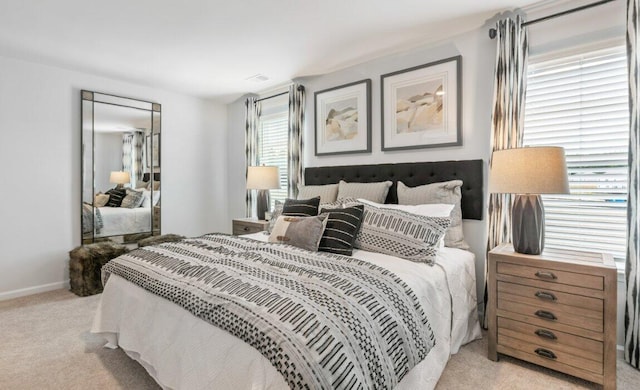 bedroom featuring light colored carpet and multiple windows