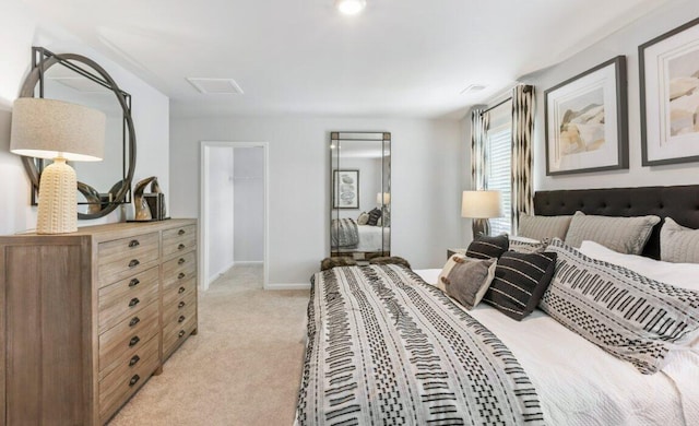 bedroom with light colored carpet and a spacious closet